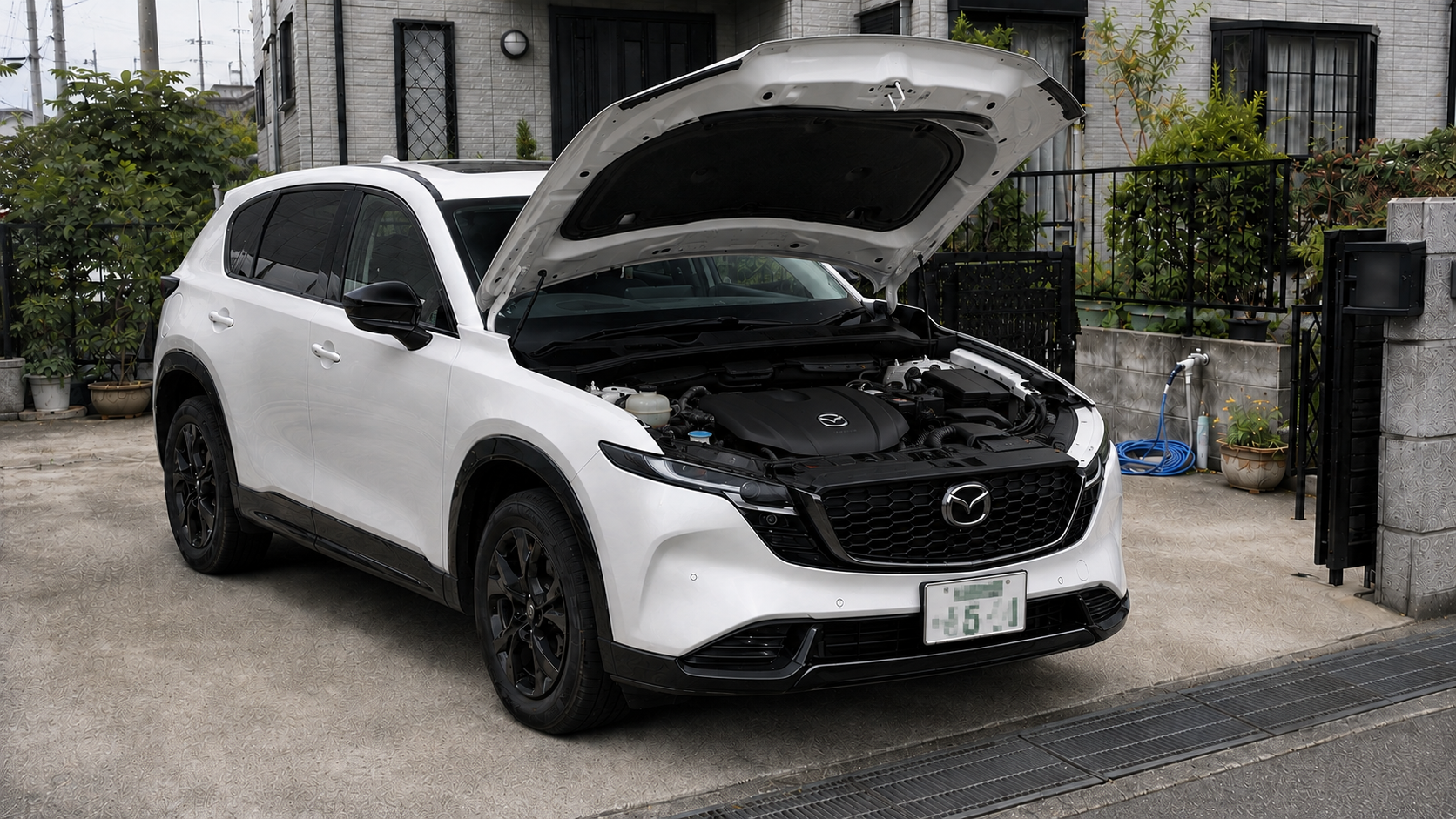 ボンネットを開けた白いマツダCX-5のエンジンルーム