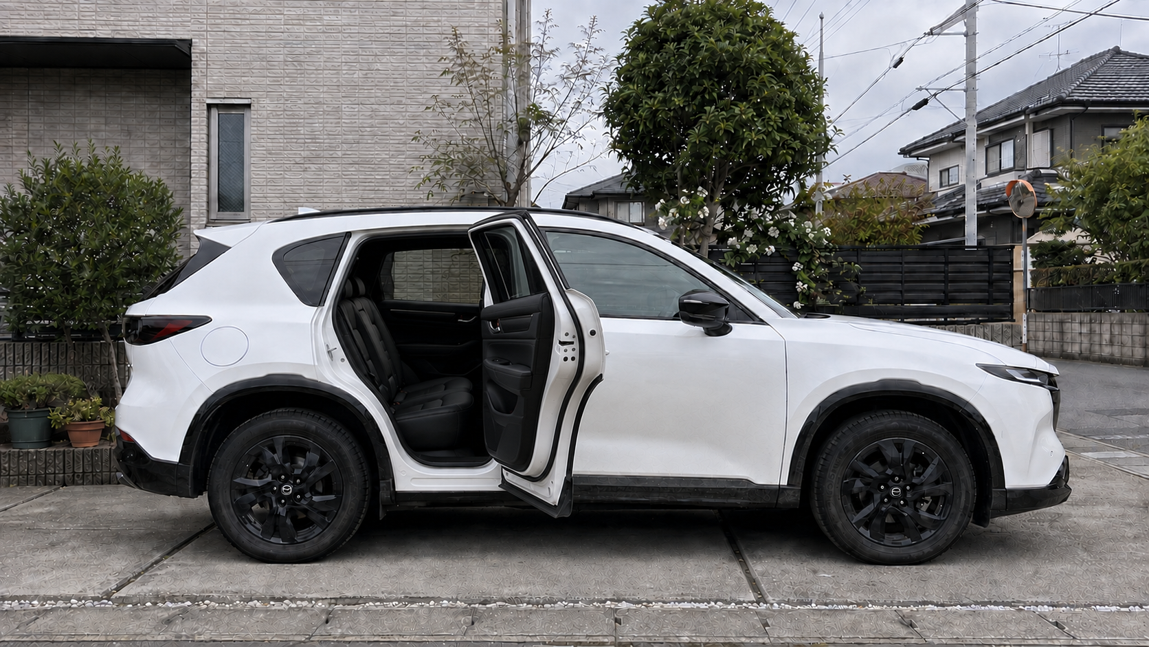 後席ドアを開けた白いマツダCX-5の黒い後部座席と乗降口