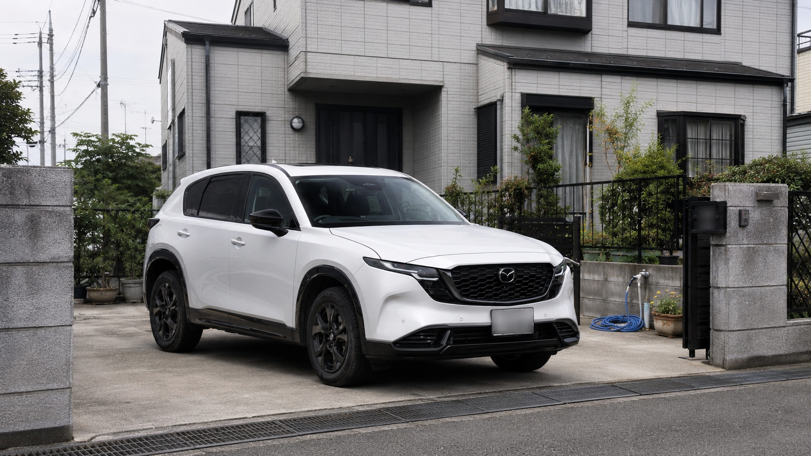住宅の駐車場に停車した白いマツダCX-5の右斜め前から見た外観