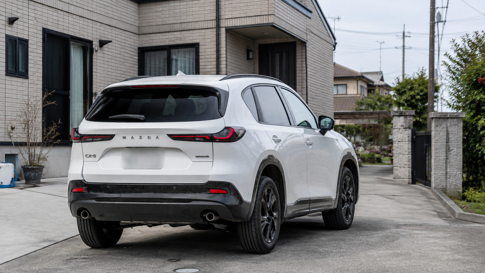 白いマツダCX-5のテールランプと2本出しマフラーを左斜め後ろから見た外観